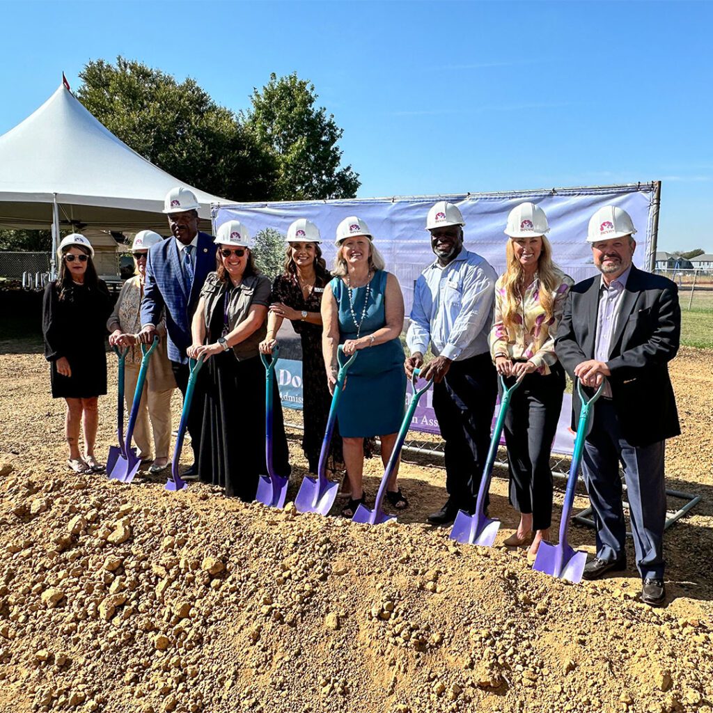 Group of people wearing hard hats at a groundbreaking ceremony