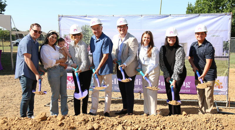 Group of people wearing hard hats at a groundbreaking ceremony