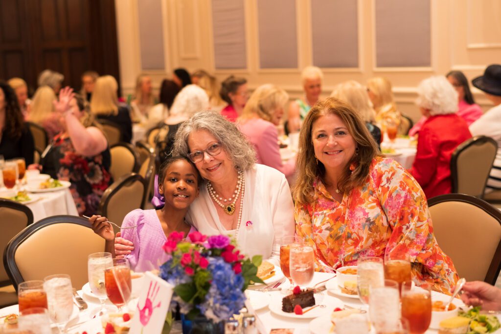 Women and child at a luncheon table smiling