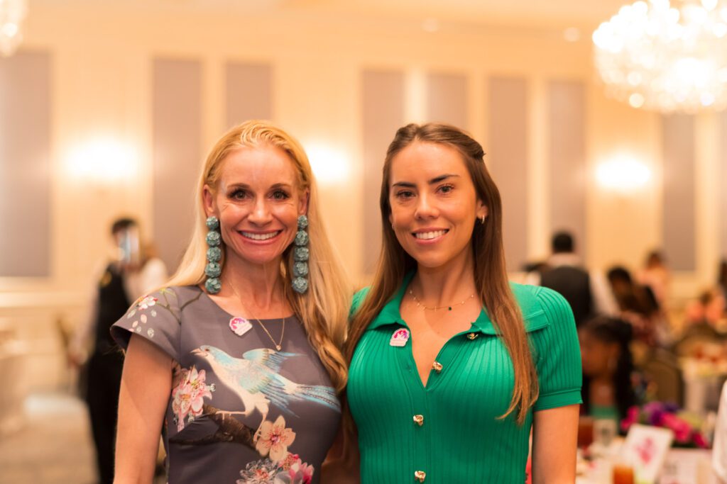 Two women in a ballroom smiling