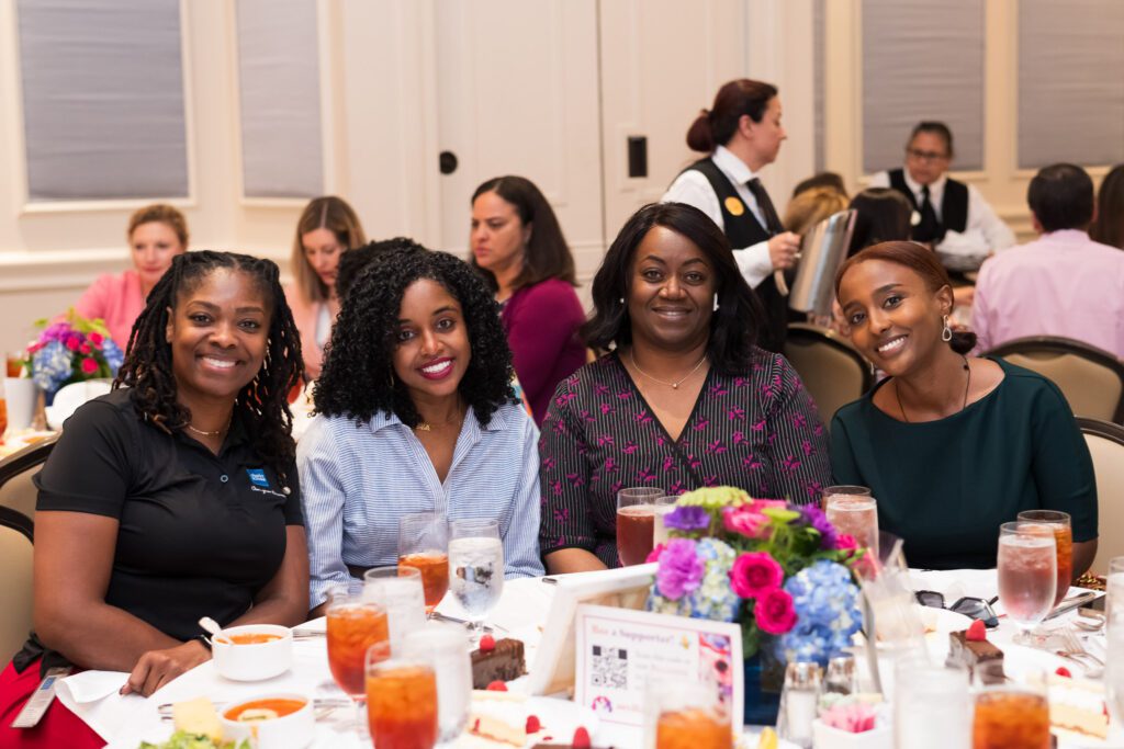 Group of women at a luncheon table smiling