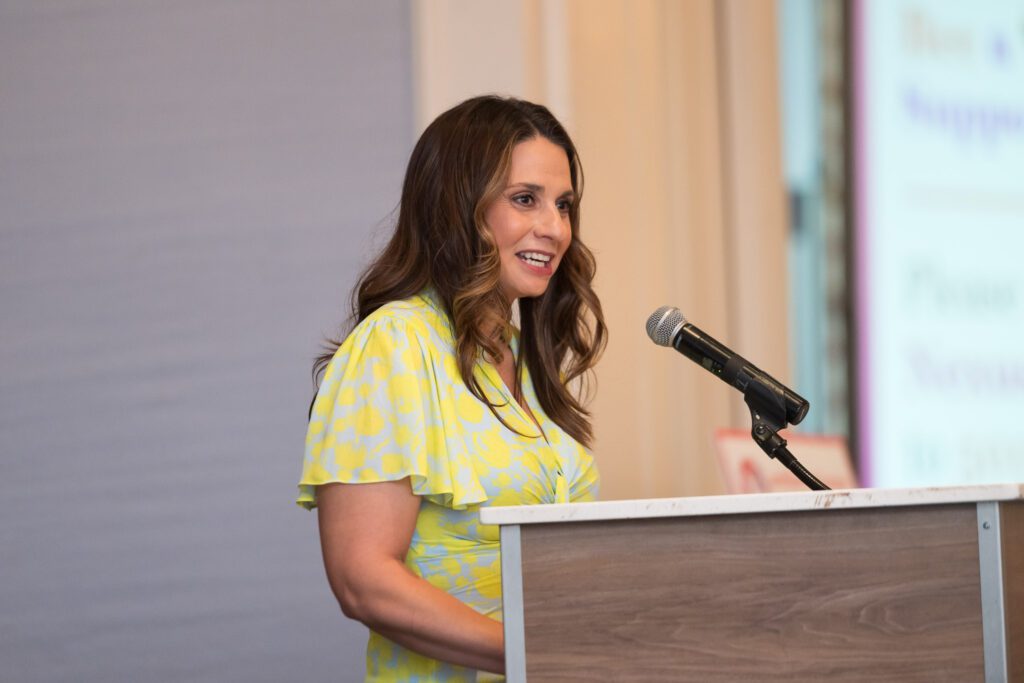 Woman laughing while speaking at a podium