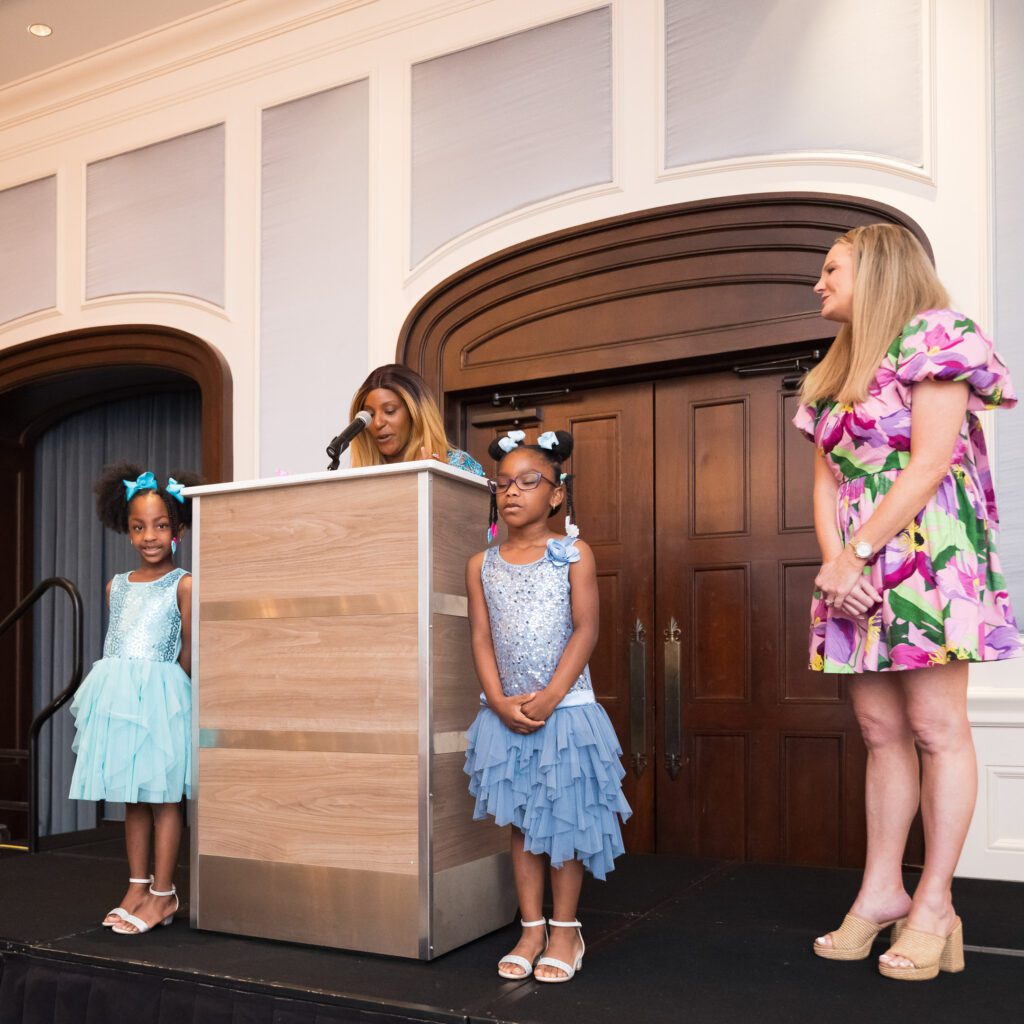 Women and children at a podium