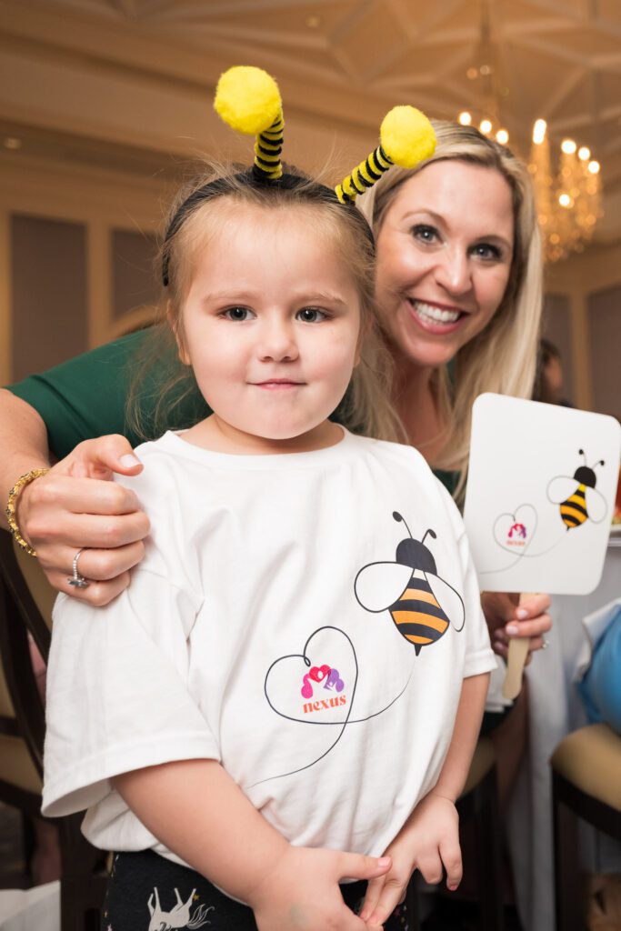 Girl in a bee headband and her mother