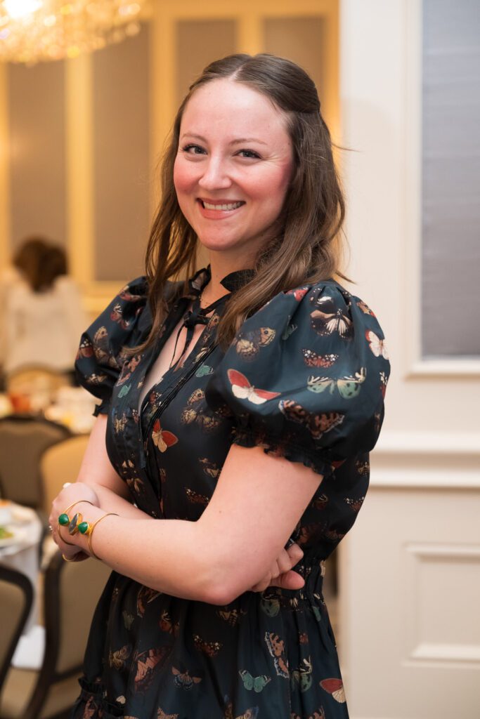 A woman standing in front of a brunch  table smiling