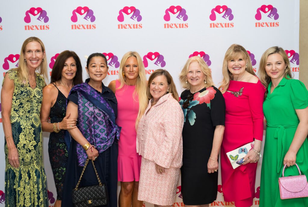 Women standing in front of a Nexus step and repeat