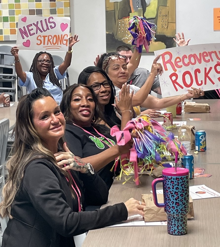 Nexus staff at Pep Rally holding signs