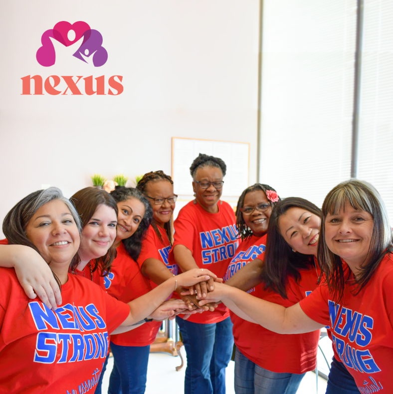 group of smiling women with red t-shirts that say nexus strong