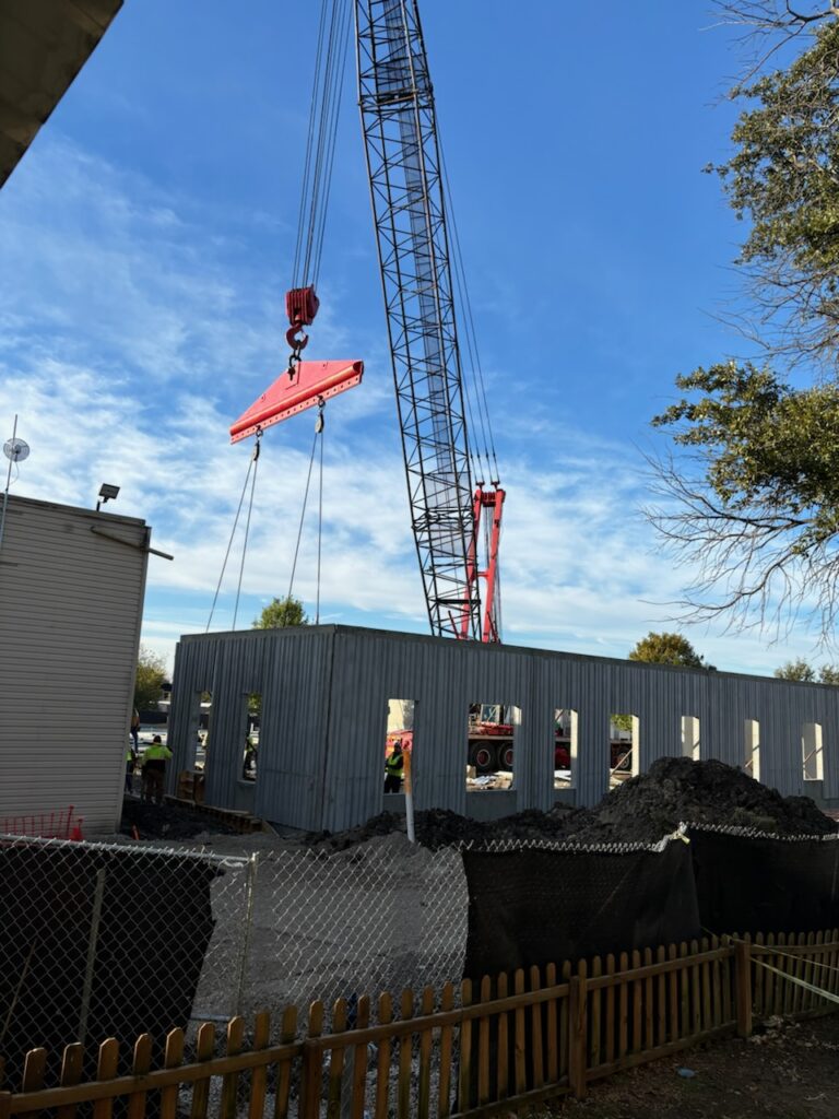 crane lifting walls to building