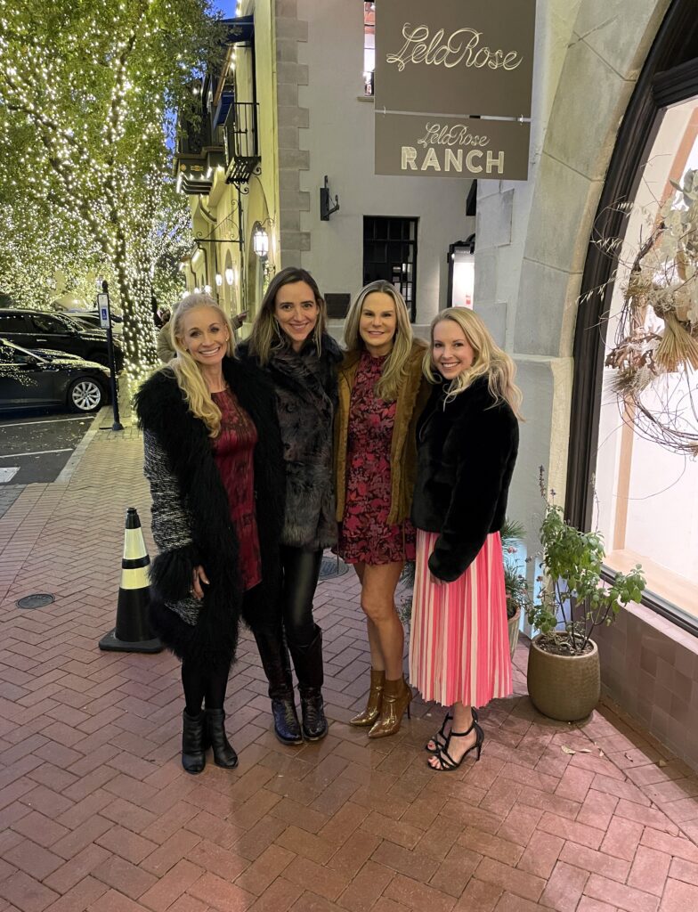 four women outside of store smiling