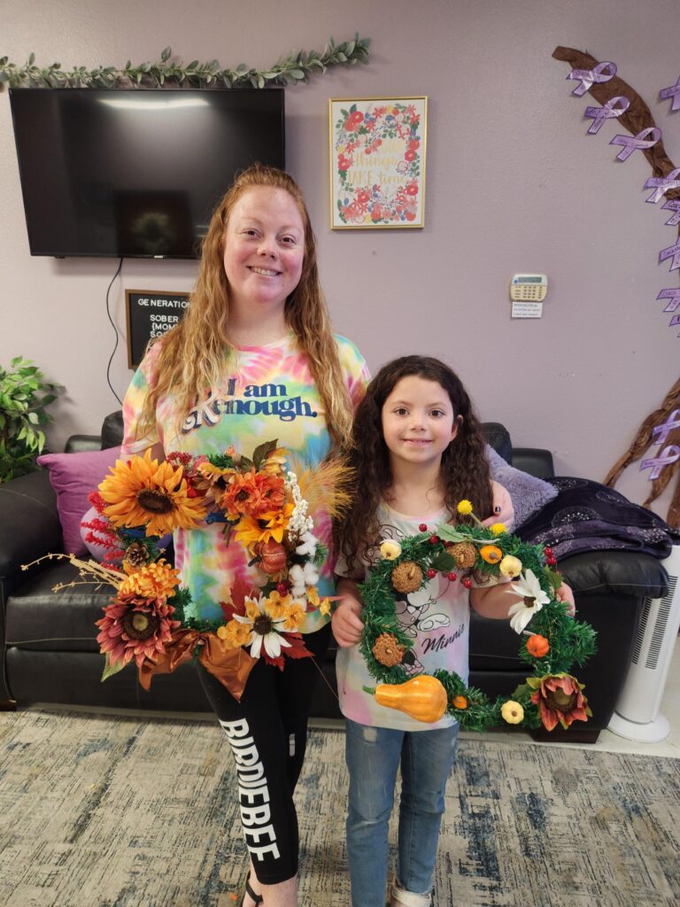 Mom and daughter holding wreaths