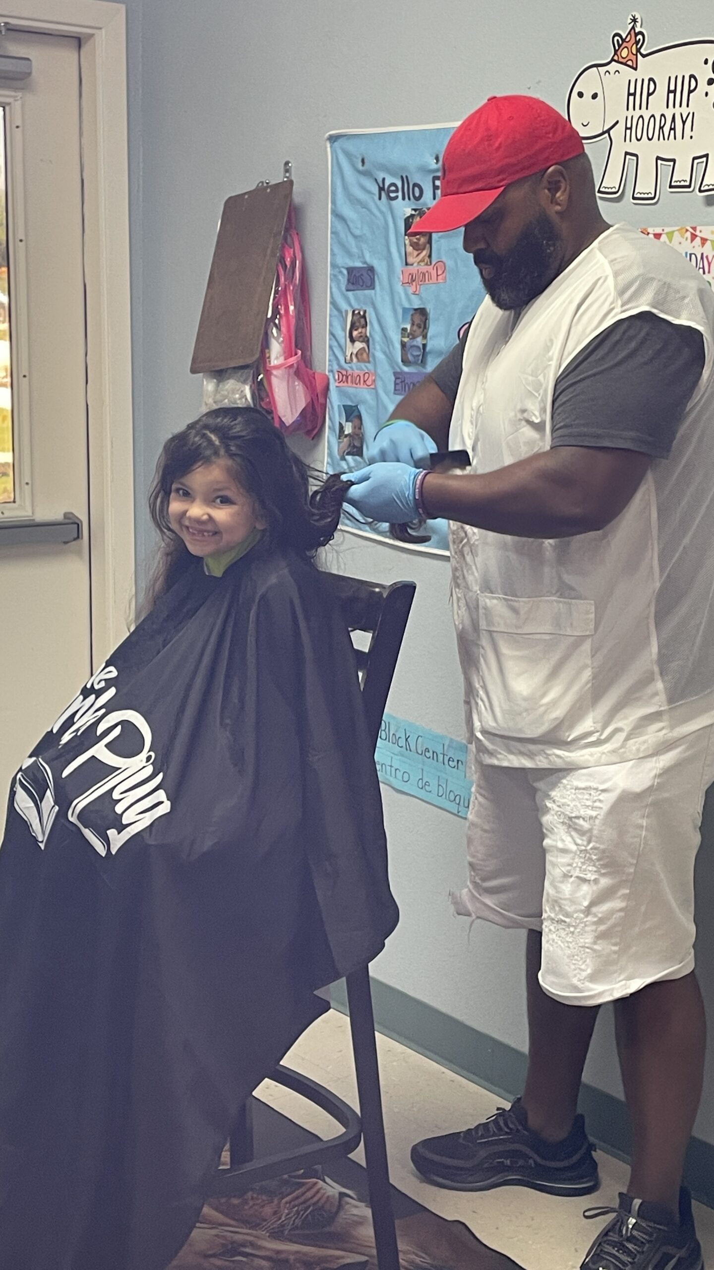 Child from the Nexus Child Development Center getting a haircut from a volunteer before school starts.